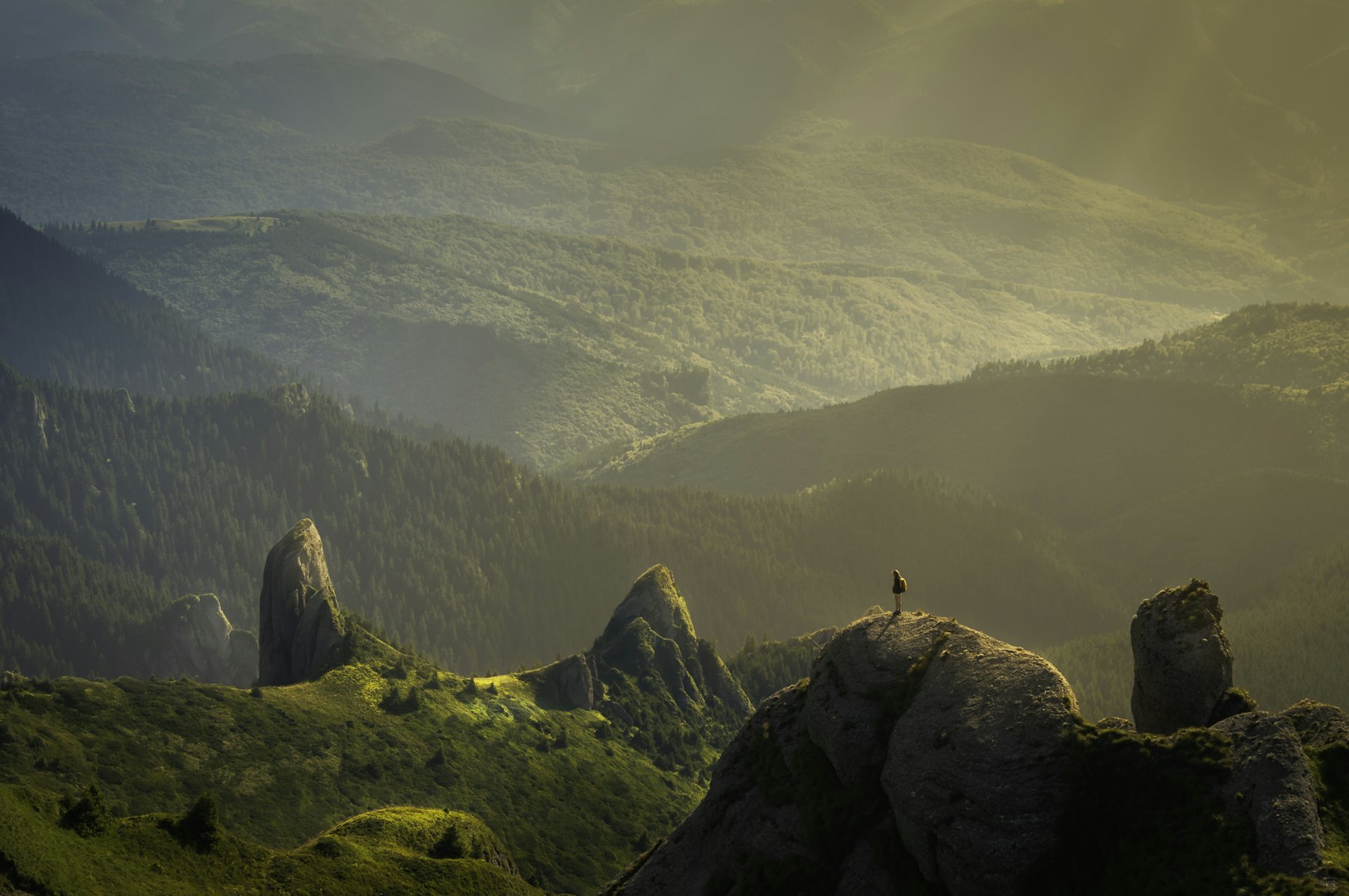 A lone figure on a misty ridge at sunrise